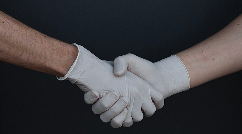 people-shaking-hands-gloves-covid